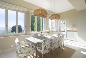 une salle à manger avec une table, des chaises et des fenêtres dans l'établissement Villa La Pax, à Mougins