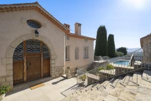 - un bâtiment avec une grande porte en bois et une piscine dans l'établissement Villa La Pax, à Mougins