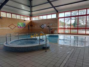 a swimming pool with a large tub in a building at Tulip Lodge at Oakdene - Passes included free! in Ferndown