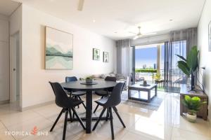 a dining room and living room with a table and chairs at Central City 3 Bed Apt, Pool, 2 Free Secured Parks in Darwin