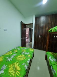 een slaapkamer met een bed met een groen dekbed bij MONTEMAR Casa 2 in Santiago