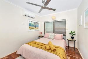 a bedroom with a bed and a ceiling fan at Tranquil Townhouse Huge Pool & Golf Course Views in Casuarina +11 photos
