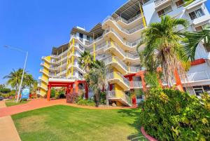 an apartment building with palm trees and a lawn at Marina Magic 2 Bed, 2 Bath Apt Stunning Views in Larrakeyah