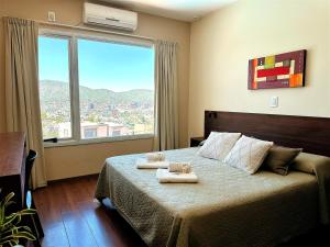 a bedroom with a bed with two towels on it at Alamo Hotel in Villa Carlos Paz +40 photos