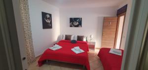 una camera da letto con un letto rosso e una sedia di La Casa Dei Greci a Agrigento