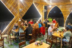 峰牙Green Riverside Cosy Home的一群人坐在餐厅的桌子旁