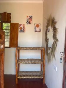 una habitación con un estante y algunas fotos en la pared en Paje Village House, en Paje
