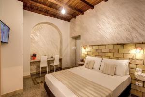 罗马Colosseo Accomodation Room Guest House的一间卧室，配有一张床和一张桌子和椅子
