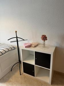 une table blanche avec un vase de fleurs dessus à côté d'un lit dans l'établissement Casa Rural Fuente la Teja, à Espinosa de Henares 40 autres photos
