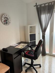 un bureau noir avec une chaise et un réveil dans l'établissement Casa Rural Fuente la Teja, à Espinosa de Henares