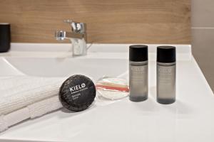 a bathroom sink with two bottles of cosmetics on it at OVELIA Epinay-sur-Orge - Le Grand Marronnier in Épinay-sur-Orge