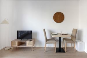 a dining room with a table and a clock on the wall at OVELIA Epinay-sur-Orge - Le Grand Marronnier in Épinay-sur-Orge