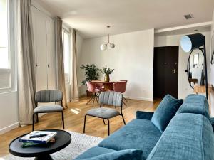 Una sala de estar con un sofá azul y una mesa. en Pick A Flat's Apartment in Grands-Boulevards - Boulevard Saint-Denis, en París