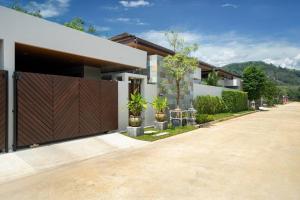 a house with a wooden gate in a driveway at Wila villas Phuket Free Airoport Pick up from 7 days in Phuket