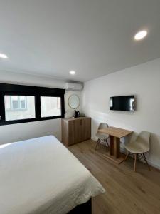 a bedroom with a bed and a table and a tv at Sha Sho in Mostar