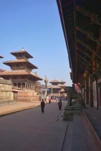 un gruppo di persone che camminano per una strada con edifici di Jhigu Homestay Patan a Kathmandu