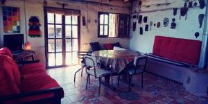 a room with a table and chairs and a couch at La comarca Eco-casa in Río Ceballos