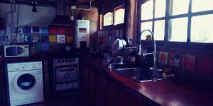 a kitchen with a sink and a washing machine at La comarca Eco-casa in Río Ceballos