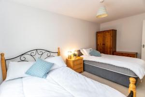 sypialnia z 2 łóżkami i szafką nocną w obiekcie Florey Court, Long Stays Disc, Sleeps 6 in 2 Bedrooms, Parking w mieście Swindon