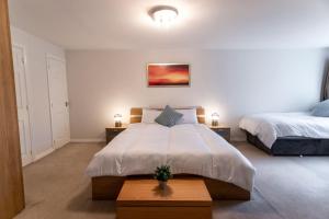 sypialnia z 2 łóżkami i stołem z 2 lampami w obiekcie Florey Court, Long Stays Disc, Sleeps 6 in 2 Bedrooms, Parking w mieście Swindon