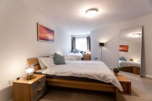 sypialnia z dużym łóżkiem i dużym lustrem w obiekcie Florey Court, Long Stays Disc, Sleeps 6 in 2 Bedrooms, Parking w mieście Swindon