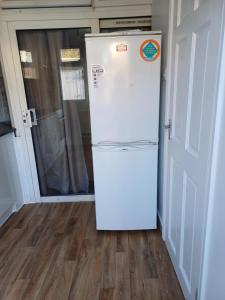 a white refrigerator in a room with a door at Studio Apartment in London in Edmonton