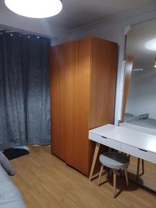 a bedroom with a white desk and a wooden cabinet at Studio Apartment in London in Edmonton