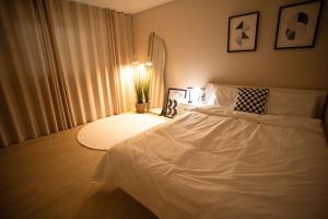 庆州Gyeongju Record Stay Near tourist attractions的卧室配有白色的床和灯