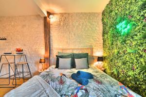 ein Schlafzimmer mit einem Bett und einer grünen Wand in der Unterkunft Jungle Rochelaise - Coeur de ville, Entièrement Rénovée, Tv 4K, Fibre, Quartier Porte Royale in La Rochelle