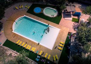 an overhead view of a large swimming pool with yellow chairs at Camping Golfo dell'Asinara in Platamona