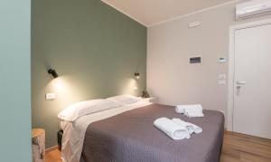 a bedroom with a bed with two towels on it at Hotel Perla in Castiglione della Pescaia