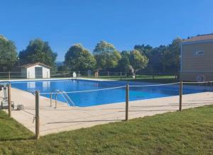 a large swimming pool with a fence around it at El Relax, La Puebla De Castro in La Puebla de Castro
