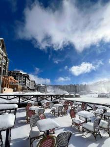 a group of tables and chairs covered in snow at SKY PEAK KRALJEVI ČARDACI APARTMENT in Kopaonik