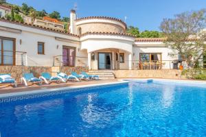 a villa with a swimming pool in front of a house at V024 - Villa Colina in Palau-Saverdera
