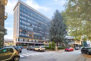a large building with cars parked in front of it at Moderno Attico con Vista Panoramica e Piscina in Turin