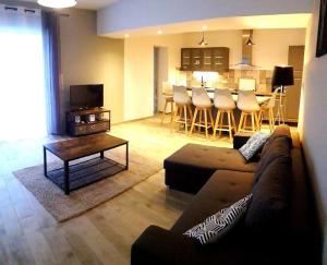 een woonkamer met een bank en een tafel en een keuken bij Aillan Hervé villa avec piscine privée chauffée in Mirabel-aux-Baronnies