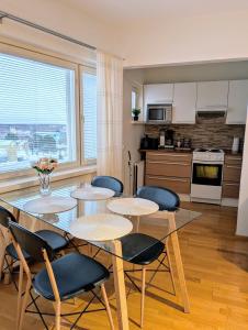 una cucina con quattro tavoli e sedie in una stanza di 18 - Cozy apartment with view, top 7th floor a Kemi