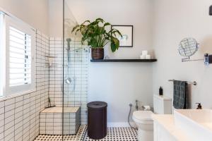 a bathroom with a toilet and a plant on the wall at Home for 8 in central Green Point in Cape Town