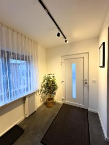 a hallway with a door and a plant next to a window at Modernes Ferienhaus mit Kochinsel, Garten, 2 Parkplätze inkl, 4-8 Pers in Böblingen