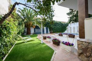 a garden with green grass and purple flowers and plants at Calandria Madrid in Madrid