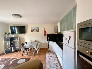a kitchen with a table and a white refrigerator at Casa Gomes in Calheta