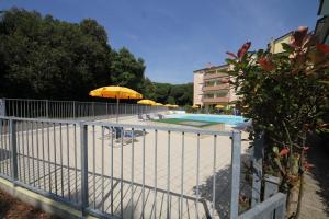 a swimming pool with umbrellas and chairs and a pool at Rosolina cozy flat wth pool in Rosolina Mare