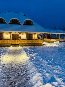 un edificio coperto di neve nella neve di Casa Moroșanului Vișeu de Sus a Vişeu de Sus
