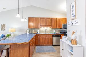 a kitchen with wooden cabinets and a blue counter top at Baywatch D11 in Pensacola Beach