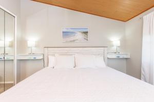 a white bedroom with a large bed with two pillows at Baywatch D11 in Pensacola Beach +23 photos