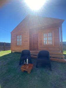 a log cabin with two chairs and a table at La Vita CdelU in Concepción del Uruguay