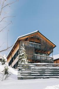 un edificio nella neve con un albero di Arlberg Lodges a Stuben am Arlberg