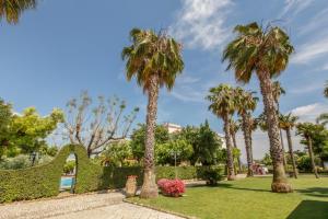 a park with palm trees and grass and flowers at Villa Irlanda Grand Hotel in Gaeta