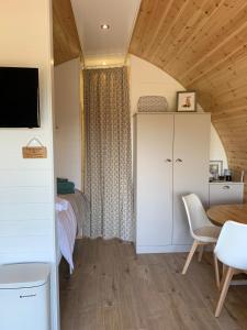 a small room with a bed and a table and chairs at Worm Dale- Bugthorpe Grange Glamping in Stamford Bridge +20 photos