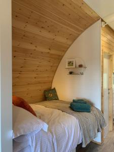 a bed in a room with a wooden ceiling at Worm Dale- Bugthorpe Grange Glamping in Stamford Bridge